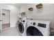 Well-equipped laundry room with modern washer and dryer, wire shelving, and light tile flooring at 13312 Chopin Ridge Rd, Huntersville, NC 28078
