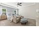 Spacious main bedroom featuring a ceiling fan, patterned wall, bedside tables, and upholstered chairs with ottoman at 13312 Chopin Ridge Rd, Huntersville, NC 28078
