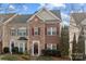 Brick front townhouse with landscaping and a charming porch at 13823 Waverton Ln, Huntersville, NC 28078