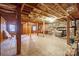 Unfinished basement with exposed beams, brick floor, and stone fireplace at 2452 Nc 182 Hwy, Lincolnton, NC 28092