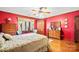 Bedroom with red walls, wood floors, and built-in wooden cabinets and dresser at 2452 Nc 182 Hwy, Lincolnton, NC 28092