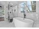 Luxurious bathroom with soaking tub, walk-in shower, and marble floors at 2717 Madison Oaks Ct, Charlotte, NC 28226