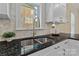 Modern kitchen sink with hexagon tile backsplash and granite countertops at 2717 Madison Oaks Ct, Charlotte, NC 28226