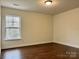 Simple bedroom with hardwood floors and a large window at 5121 Stone Park Dr, Charlotte, NC 28269