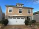 Tan two-story house with white two-car garage and landscaping at 5121 Stone Park Dr, Charlotte, NC 28269