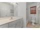 Bright bathroom featuring white cabinets, tiled floors, and a shower with a window at 6654 Kingbird Ct, Charlotte, NC 28215