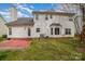 View of the white, two-story home showcasing its backyard patio and well-manicured lawn at 6654 Kingbird Ct, Charlotte, NC 28215