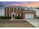 Charming two-story brick home featuring black shutters, a two-car garage, and a manicured lawn at 6654 Kingbird Ct, Charlotte, NC 28215