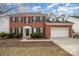 Charming two-story brick home featuring black shutters, a two-car garage, and a manicured lawn at 6654 Kingbird Ct, Charlotte, NC 28215