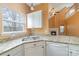 Sunlit kitchen featuring granite countertops, white cabinetry, and modern stainless steel dishwasher at 6654 Kingbird Ct, Charlotte, NC 28215