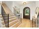 Bright entryway with hardwood floors, elegant staircase, and arched doorway at 669 Dogwood Ln, Davidson, NC 28036