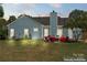 Backyard view showcasing seating area, well-maintained lawn, and blue siding at 8523 Albury Walk Ln, Charlotte, NC 28277