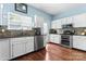 Charming kitchen featuring white cabinets, updated appliances, granite countertops, and hardwood floors at 8523 Albury Walk Ln, Charlotte, NC 28277