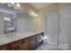 Double vanity bathroom with dark brown cabinets and a large mirror at 17627 Caddy Ct, Charlotte, NC 28278