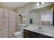 Bright bathroom featuring a white vanity, colorful shower curtain and functional storage shelving at 17627 Caddy Ct, Charlotte, NC 28278