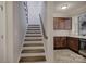 Stairway with dark wood steps and trim leading to the main living area and kitchen at 17627 Caddy Ct, Charlotte, NC 28278