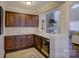 Wet bar with dark wood cabinets, quartz countertops, and wine cooler at 17627 Caddy Ct, Charlotte, NC 28278