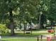Lush backyard with mature trees and access to a lake with a wooden swing at 1934 Hickory Hills Dr, Denver, NC 28037