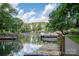 Picturesque waterfront view featuring a dock, boat, and serene lake reflecting the clear blue sky at 1934 Hickory Hills Dr, Denver, NC 28037