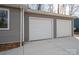 Close up view of the two-car garage with white doors and gray siding of this home at 1934 Hickory Hills Dr, Denver, NC 28037