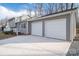 View of the home's two-car garage featuring white doors and a concrete driveway, with trees providing a backdrop at 1934 Hickory Hills Dr, Denver, NC 28037