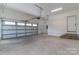 Large garage with an overhead door, brick steps leading to side door, concrete floors, and ample space at 2657 Polo Ln, Maiden, NC 28650