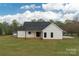 Back exterior of home, featuring white siding, windows, and glass-door access to outdoor space at 2657 Polo Ln, Maiden, NC 28650