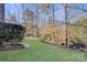 Landscaped backyard with grassy area and wooded backdrop at 8502 Sagekirk Ct, Charlotte, NC 28278