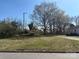 A vacant lot with mature trees is ready for development under a clear, blue sky at 1319 7Th St, Statesville, NC 28677