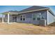 Gray house exterior with covered patio, AC unit, and grassy backyard at 1535 Harper Landing Blvd, Stanley, NC 28164