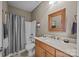 Well-lit bathroom featuring a vanity, mirror, shower and tub with a gray shower curtain at 18119 Coulter Pkwy, Cornelius, NC 28031