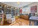 Spacious bedroom with hardwood floors, large window, built-in shelving, and an armchair at 18119 Coulter Pkwy, Cornelius, NC 28031
