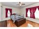 Bedroom with a bed, dark red curtains, wood floors and a ceiling fan at 1830 Light Brigade Dr, Matthews, NC 28105