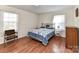 Comfortable bedroom with wood floors, a decorative bed frame, and bright natural light at 1830 Light Brigade Dr, Matthews, NC 28105