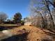 Cozy brick home nestled among mature trees, featuring a well-maintained lawn and a clear blue sky above at 1830 Light Brigade Dr, Matthews, NC 28105