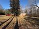 View of a cozy brick home with a well-kept lawn and mature trees casting shadows across the yard at 1830 Light Brigade Dr, Matthews, NC 28105