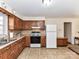 Well-lit kitchen with wooden cabinets, essential appliances, and tile flooring at 1830 Light Brigade Dr, Matthews, NC 28105