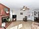 Cozy living room showcasing a brick fireplace, tiled flooring, and views to the exterior at 1830 Light Brigade Dr, Matthews, NC 28105