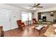 Bright living room featuring a ceiling fan, wood floors, and a cozy seating arrangement with fireplace views at 1830 Light Brigade Dr, Matthews, NC 28105