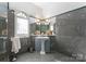 Bathroom with pedestal sink, gray tile, and an arched window at 2310 La Maison Dr, Charlotte, NC 28226