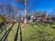 Landscaped backyard with a large tree and stone retaining wall at 353 Killian Ct, Matthews, NC 28104