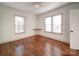 Spacious bedroom with hardwood floors, built-in shelving, and two windows at 535 Brooklyn Ave, Cramerton, NC 28032