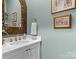 Charming powder room with ornate mirror and white vanity at 7145 Hanging Rock Ct, Denver, NC 28037