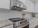 Stainless steel range and vent hood above granite countertop at 7145 Hanging Rock Ct, Denver, NC 28037