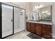 Spa-like bathroom featuring a walk-in shower with glass enclosure and dark wood cabinets at 1132 Cades Ct, Denver, NC 28037