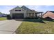 Single-story home with attached garage and landscaped lawn at 1132 Cades Ct, Denver, NC 28037