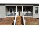 Charming brick porch with white railing, furniture, and a grill, perfect for relaxation at 118 Cypress Acres Ln, Statesville, NC 28625