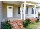 Welcoming front porch with brick stairs, white pillars, and dark shutters on a charming house at 118 Cypress Acres Ln, Statesville, NC 28625