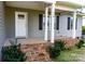 Inviting front porch with brick steps, white pillars, and a storm door entrance at 118 Cypress Acres Ln, Statesville, NC 28625