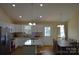 Modern kitchen featuring white cabinets, a kitchen island, and an adjacent dining area at 118 Cypress Acres Ln, Statesville, NC 28625